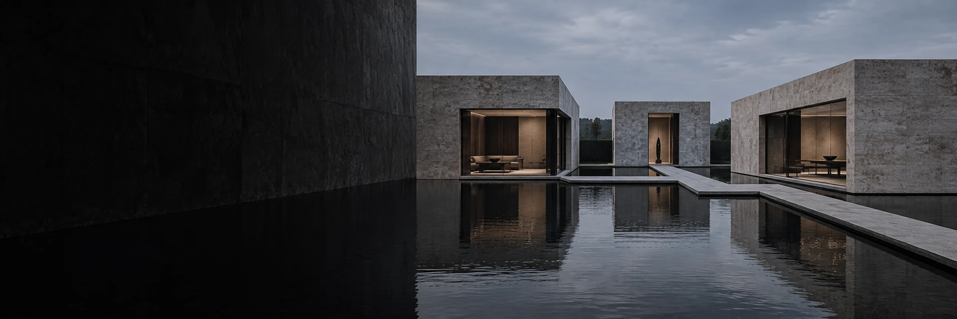 Three stone pavilions arranged around a still reflecting pool at dusk.